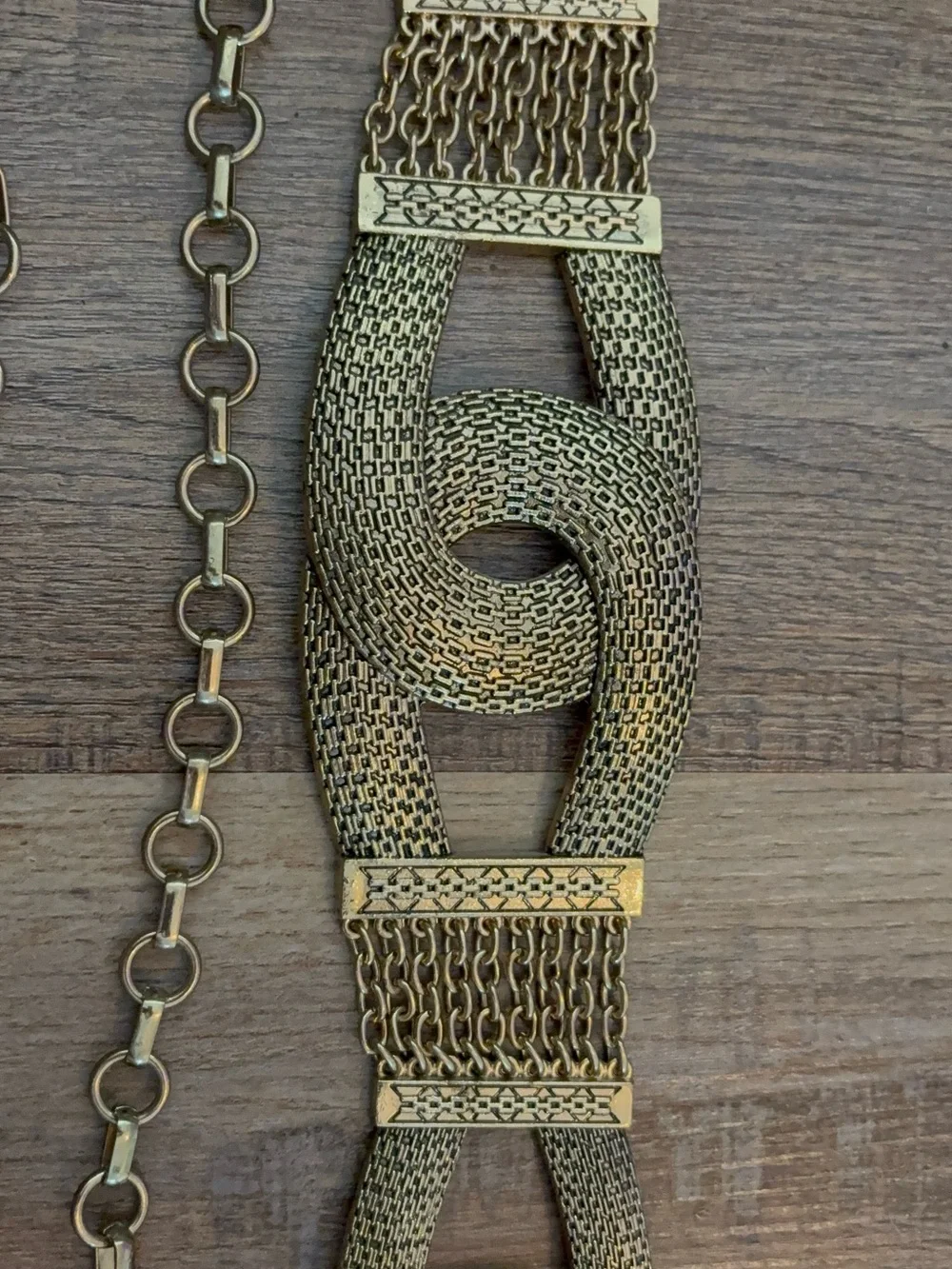 Vingold-tone statement belt featuring textured interlocking links and a chain